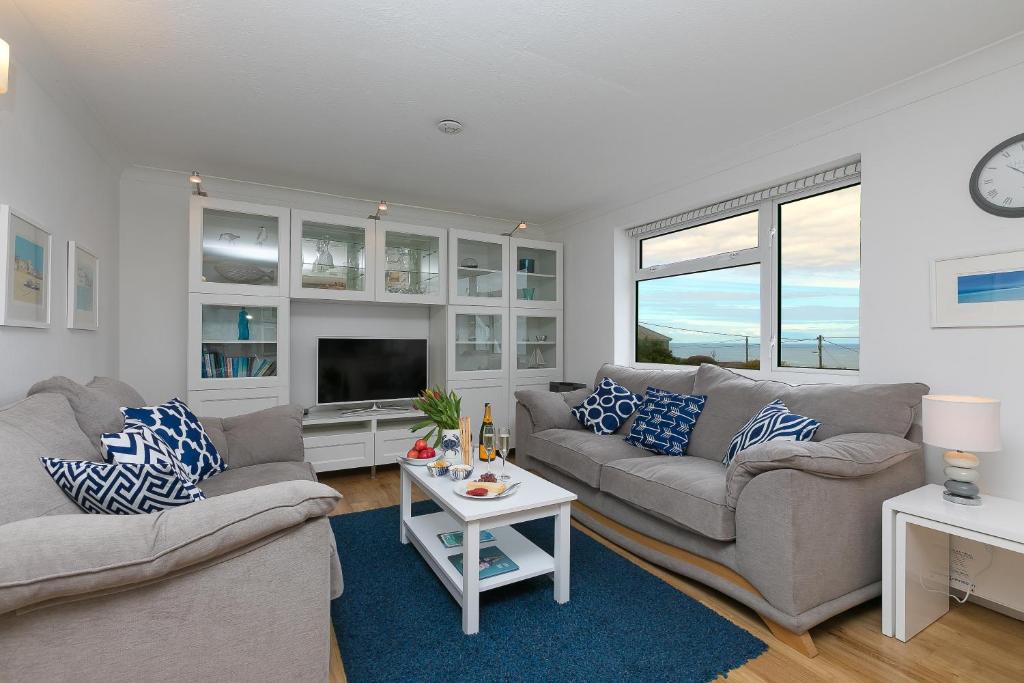 a living room with two couches and a tv at Atlantic Waves in Carbis Bay