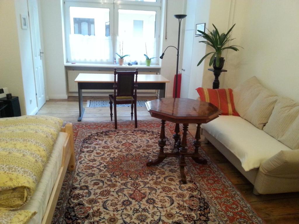 ein Wohnzimmer mit einem Sofa und einem Tisch in der Unterkunft Apartment Stadtoase Wilmersdorf in Berlin