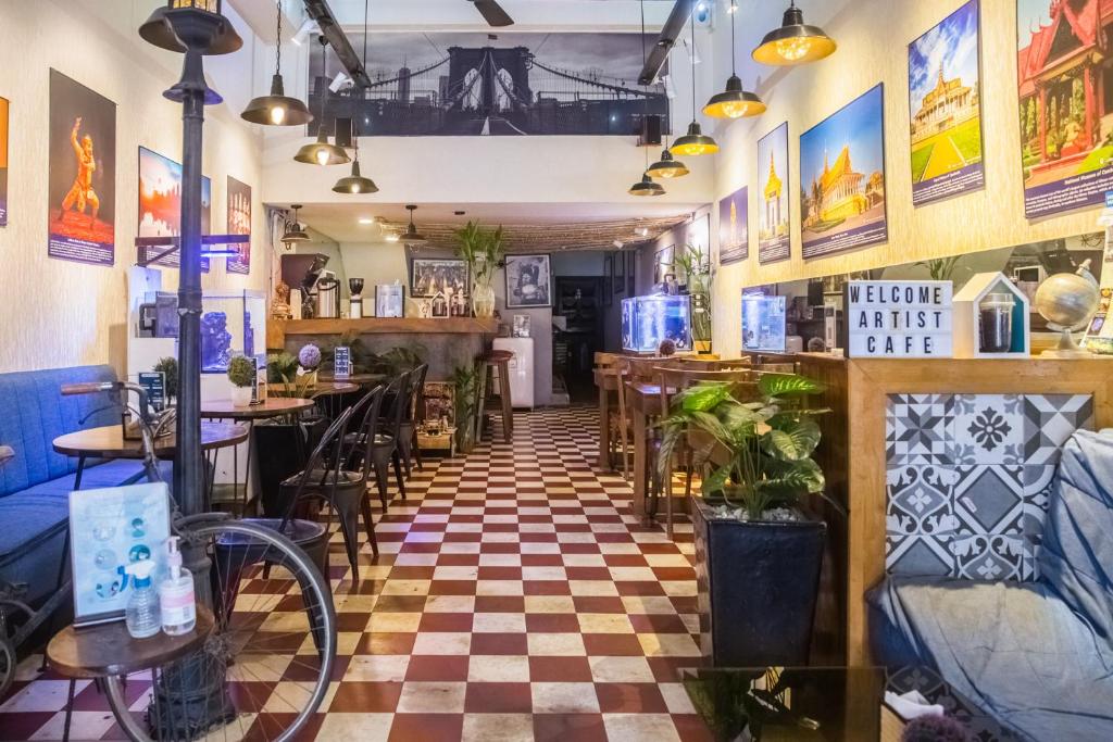 un ristorante con pavimento a scacchi di The Artist Residence a Phnom Penh