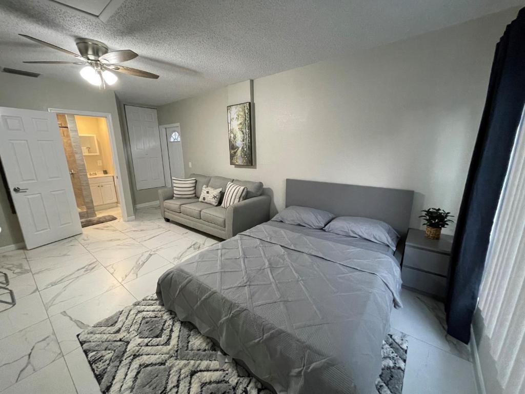 a bedroom with a bed and a couch at Adorable Suite in Tampa. in Tampa