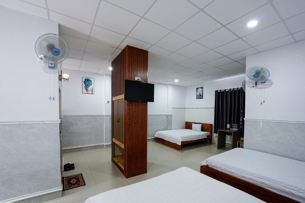 Cette chambre comprend 2 lits et une télévision. dans l'établissement Thanh Ngoc Motel 2, à Buôn Ma Thuột