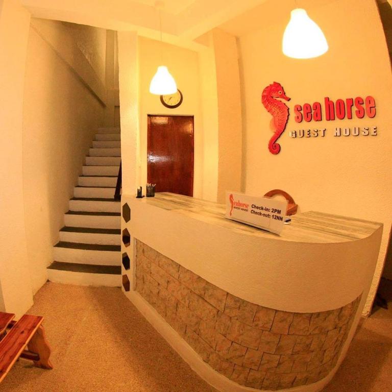a restaurant with a bar with a staircase in the background at Sea Horse Guest House in Coron