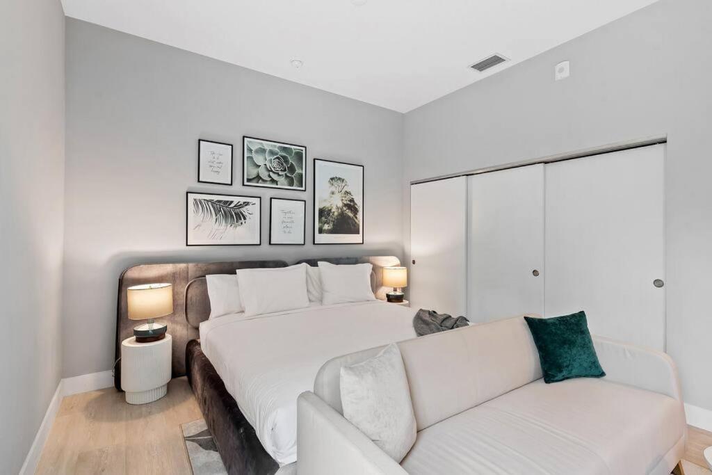 a white bedroom with a bed and a couch at Pretty Rola 304 Luxury Apt w King Bed Central Area in Fort Lauderdale