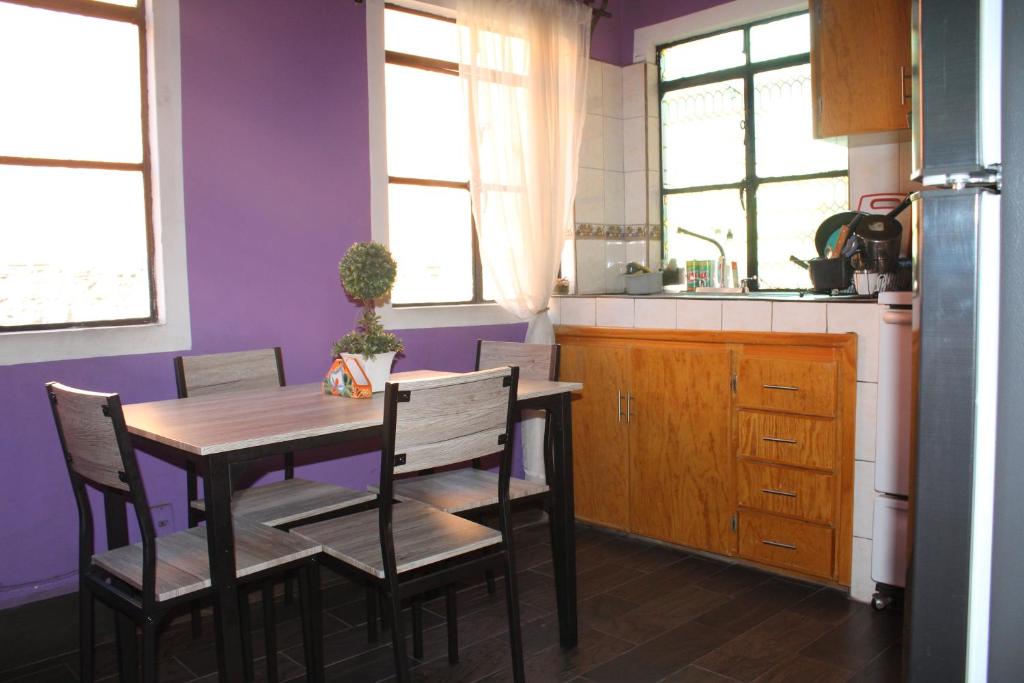 uma cozinha com mesa e cadeiras e paredes roxas em Casa Jardín em Guanajuato
