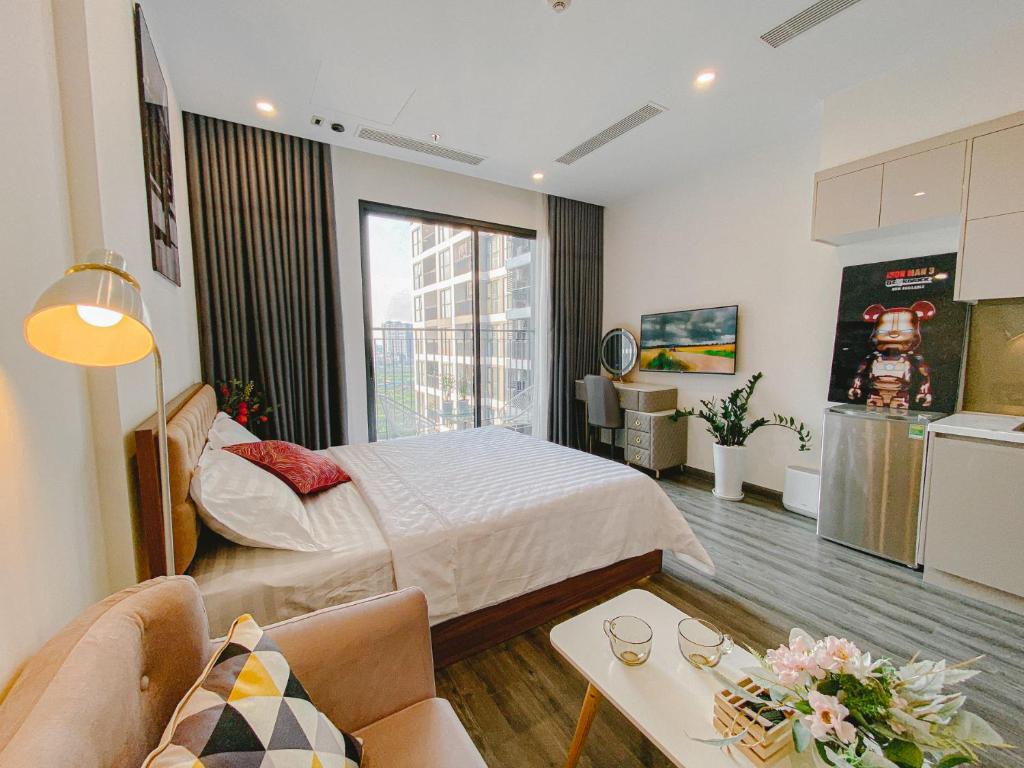 um quarto de hotel com uma cama e uma cozinha em Apartment 1BR-FL12th-R103 Building-Vinhome Ocean Park em Hanói