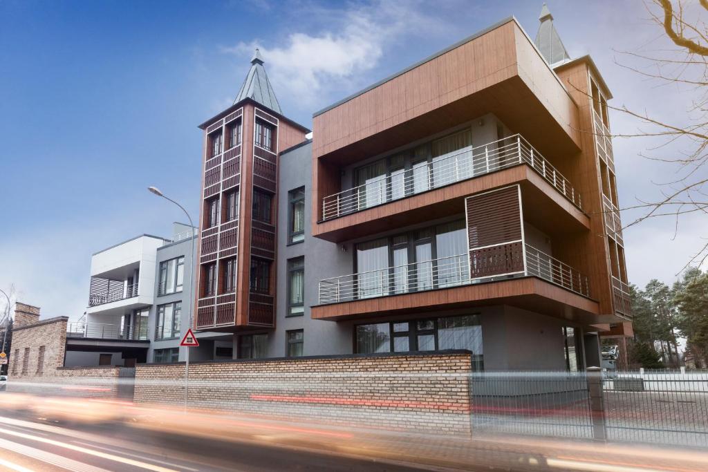 um edifício com uma torre de relógio ao lado de uma rua em Sonia Apartments em Jūrmala