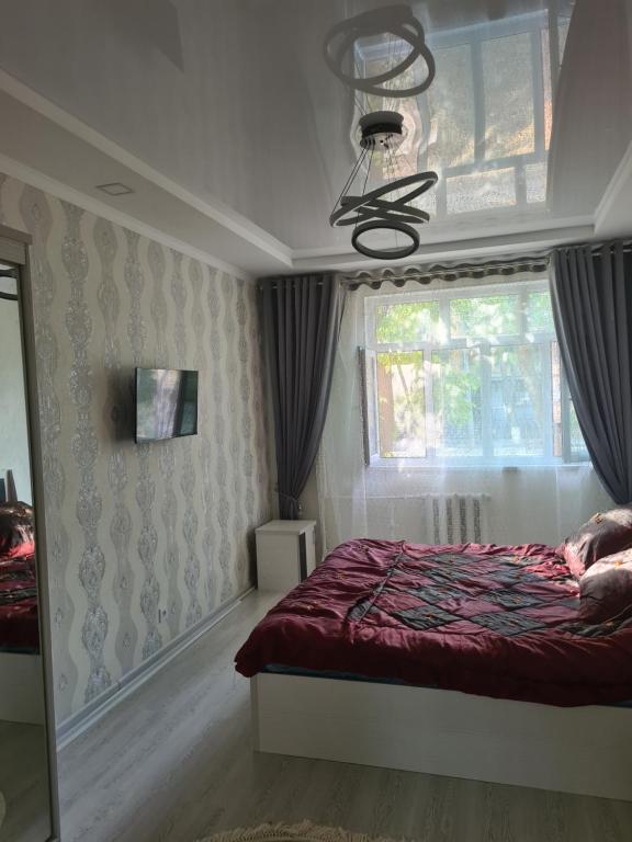 a bedroom with a bed and a window at 2-х комнатная квартира in Tashkent