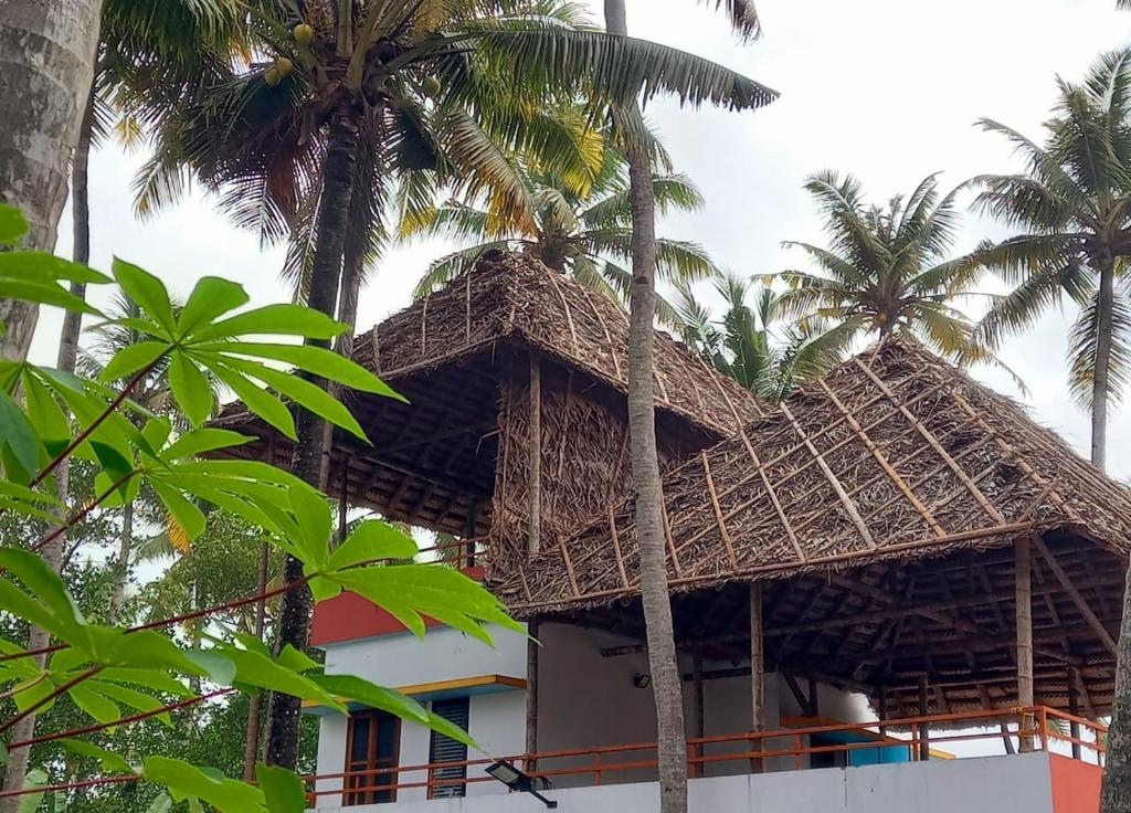 un edificio in costruzione con palme in primo piano di Madhav Mansion Beach Resort a Varkala