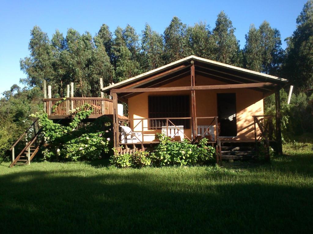 a small cabin with a deck in a field of grass at Piccolo Paradiso in La Pedrera