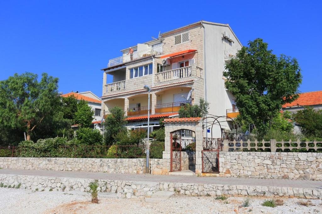 Apartments by the sea Seget Donji, Trogir - 19351 في تروغير: مبنى على جانب الطريق