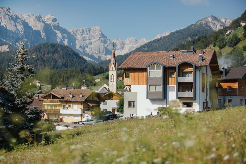 a small town with a church in the mountains at Berghotel Sanví in San Martino in Badia