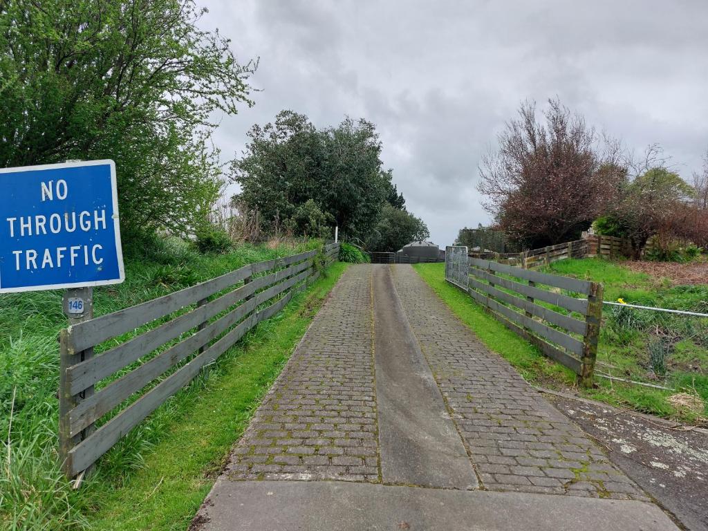 una carretera con un cartel de no a través de una valla en Rural in the city, en Palmerston North