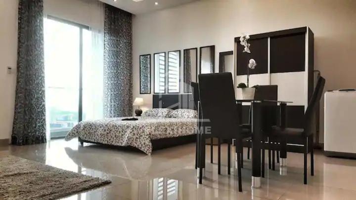 a bedroom with a bed and a table and chairs at 1-2 Guests, HBO-GO TV, Bali-Style Studio in Cybersquare, Cyberjaya by Flexihome-MY in Cyberjaya