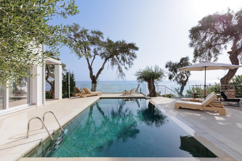 a swimming pool with a view of the ocean at Nisos Villas Corfu in Benitses