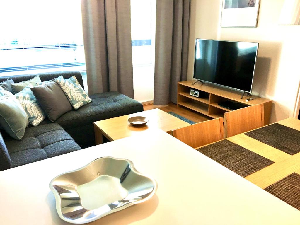 a living room with a couch and a television at Premium Chalet 4109 Blue in Vierumäki