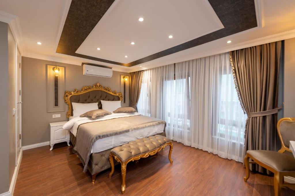 una camera con un grande letto con una panca di Azalea Mansion Oldcity a Istanbul