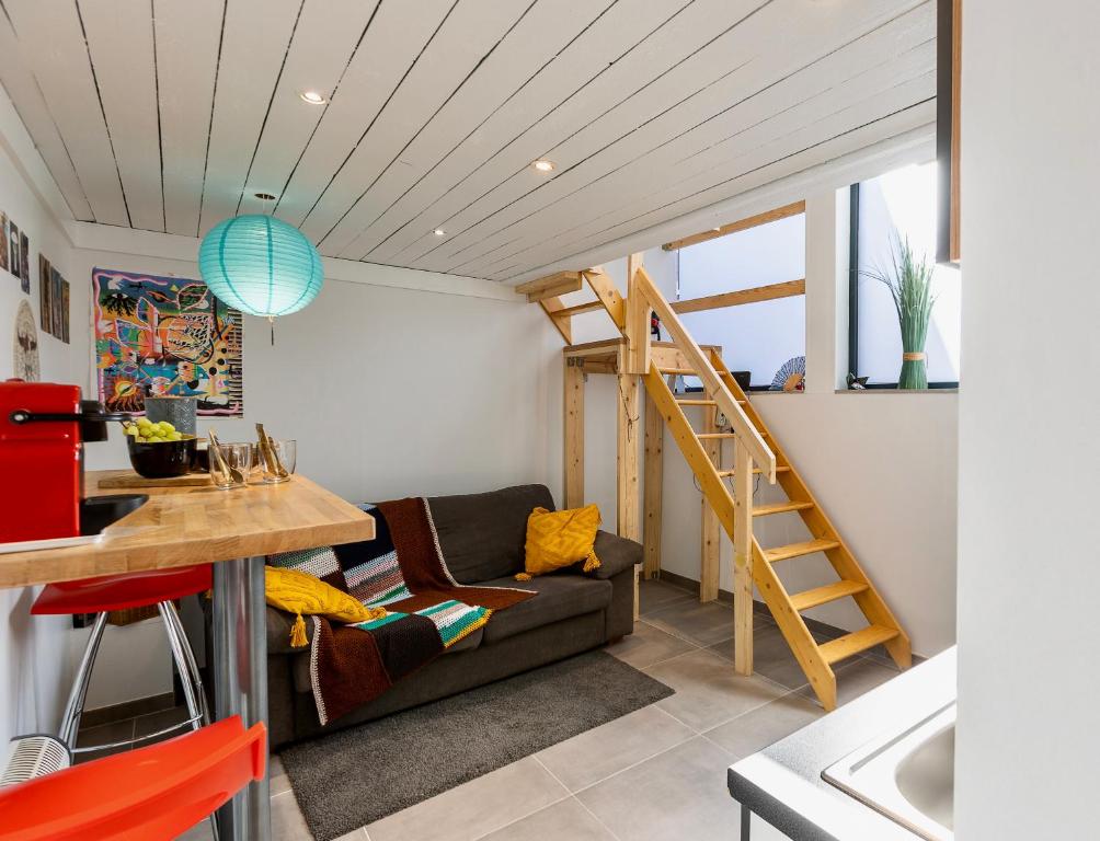 a small living room with a couch and a staircase at Le Studio Compostelle by Maison Brasseurs d'Etoiles - Appartement 2 personnes in Liège