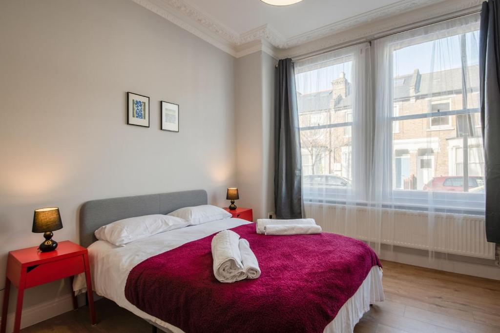ロンドンにあるComfortable flat in Hammersmithのベッドルーム1室(ベッド1台、タオル2枚付)