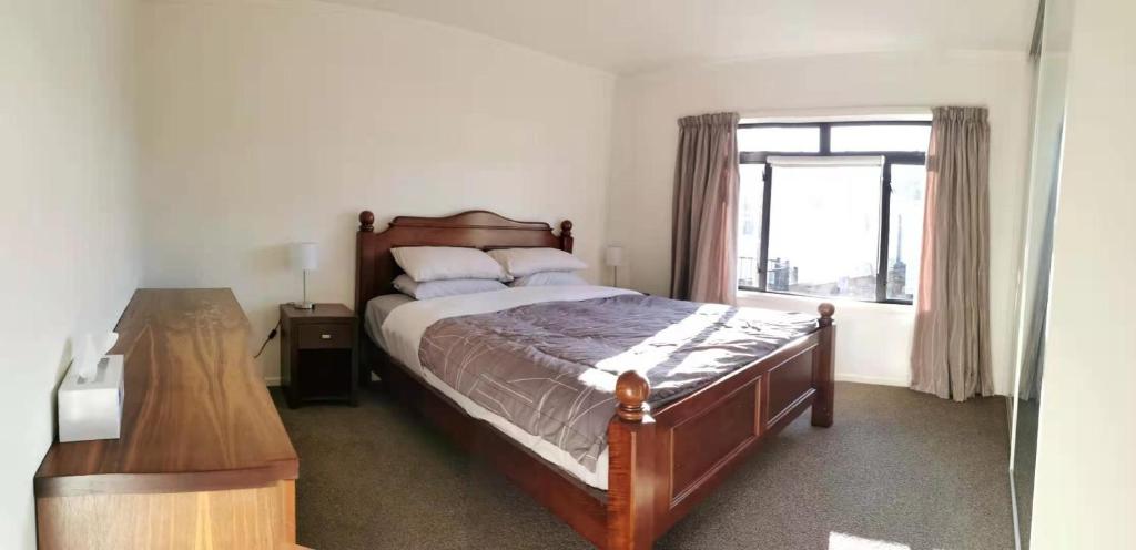 Un dormitorio con una cama grande y una ventana en Red Brick House, en Auckland