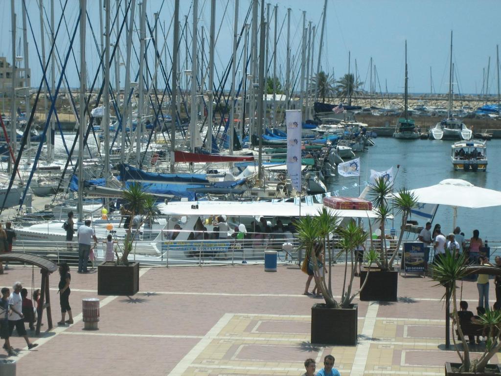 pessoas andando em torno de uma marina com barcos na água em Nomi Suites Marina Herzelia em Herzeliya