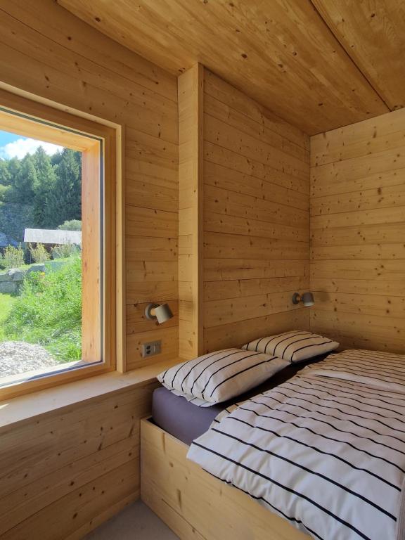 a bed in a log cabin with a window at Chalet ski-in ski-out Nendaz in Nendaz