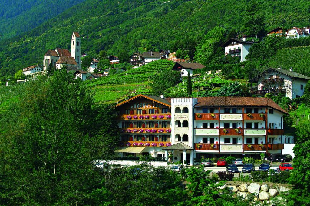 un hotel al lado de una colina con una ciudad en Hotel Marlingerhof, en Marlengo