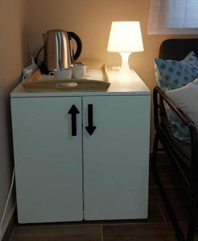 a small white cabinet with a lamp on top of it at Mike's Rooms in Kobarid