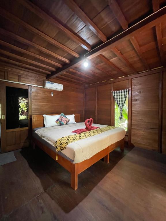 1 dormitorio con 1 cama en una habitación de madera en Bulian Homestay, en Kubutambahan