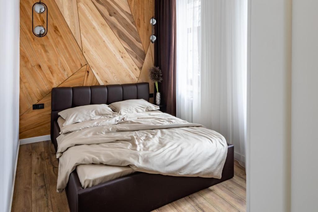 リヴィウにあるRomari Таманська 12のベッドルーム1室(黒いベッド1台、木製ヘッドボード付)