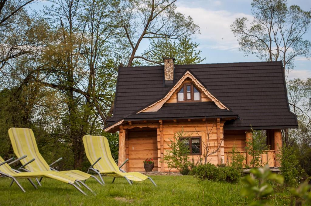 un groupe de chaises devant une cabane en rondins dans l'établissement Domek Łemkowski, à Ustrzyki Dolne