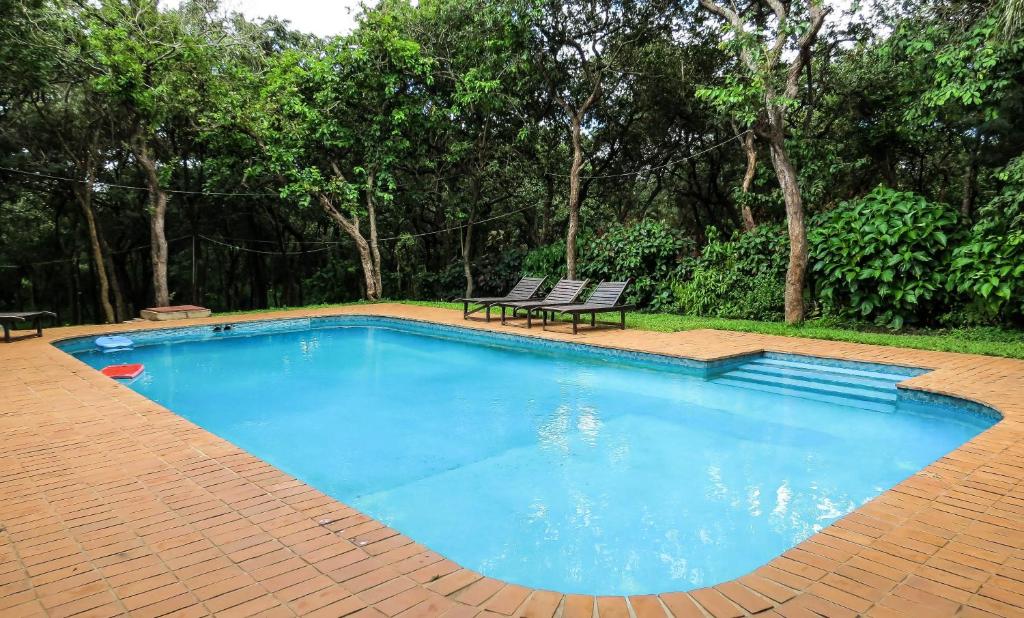 a swimming pool with a bench and a picnic table at Woodlands Lilongwe in Lilongwe