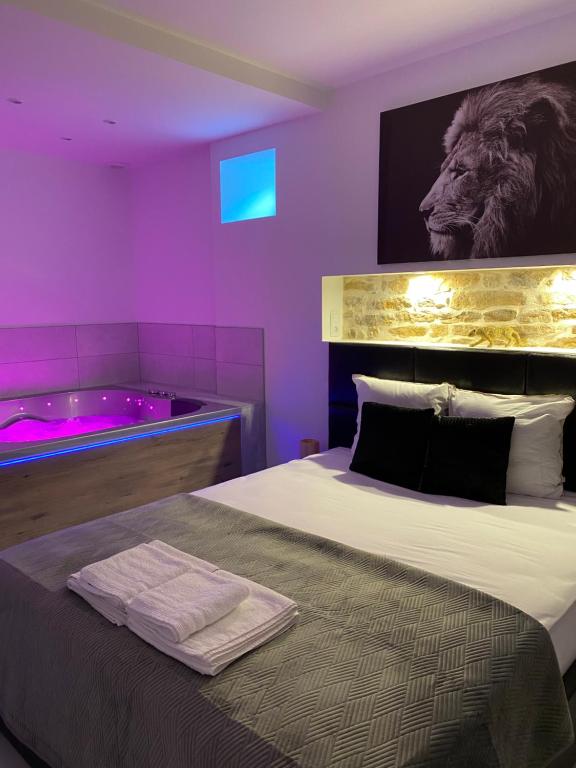 a bedroom with a bed and a tub with a lion on the wall at L’appart [é] spa in Beure