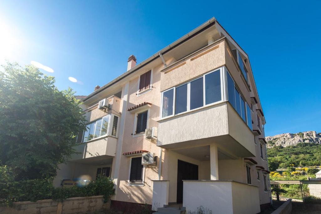 obraz domu z górami w tle w obiekcie Apartments with parking spaces Baska, Krk - 19675 w Bašce