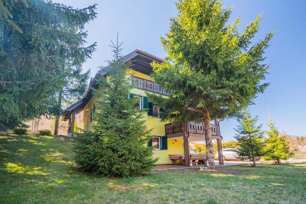 a yellow house with trees in front of it at Family friendly house with a parking space Lokve, Gorski kotar - 19457 in Lokve