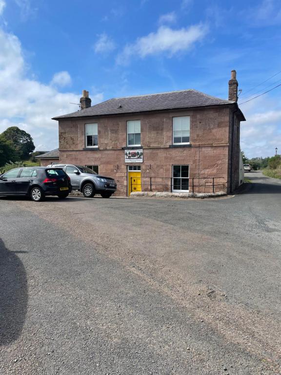 a brick building with two cars parked in front of it at Canty’s 