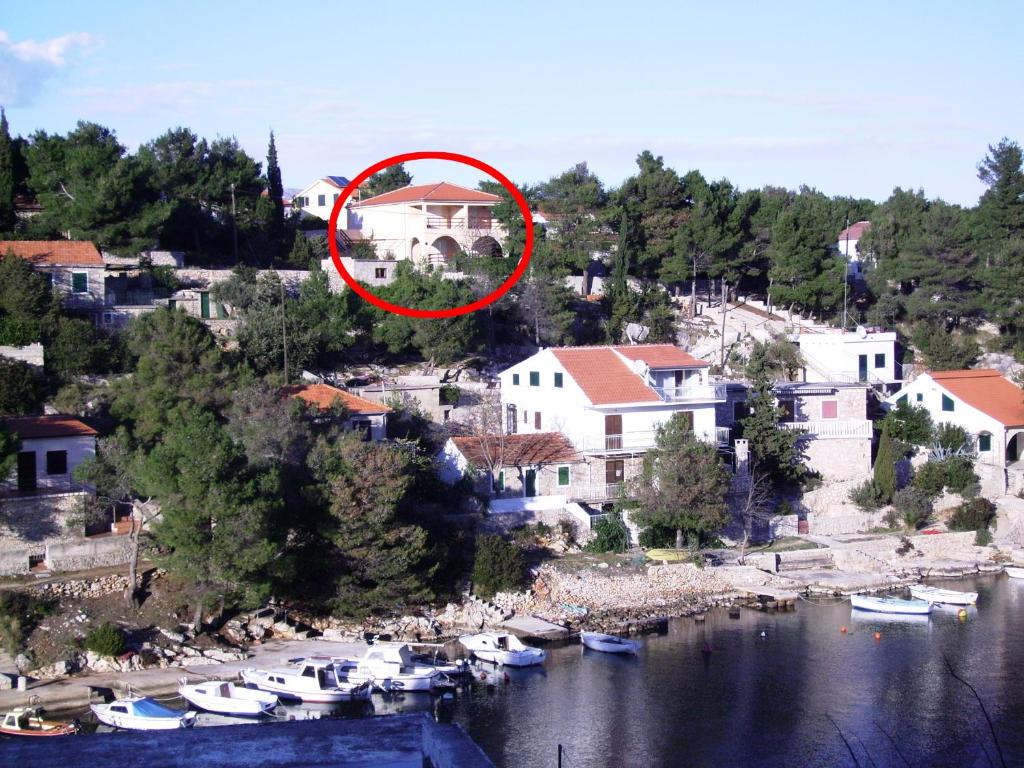 Apartments by the sea Basina, Hvar - 19668 في Vrbanj: منزل في وسط نهر مع قوارب