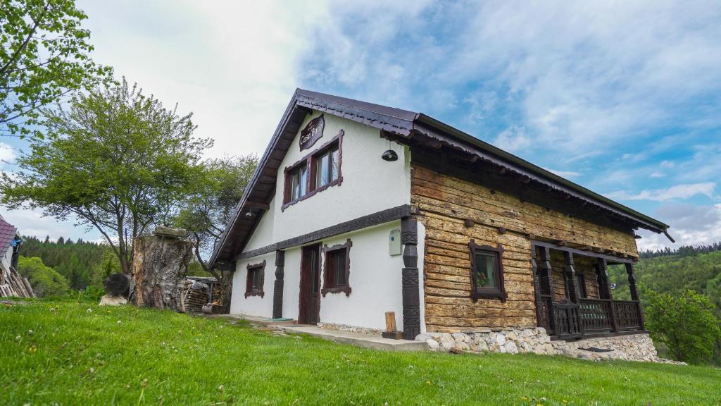 uma casa de madeira numa colina com um campo verde em Casa Bună Fundățica em Fundata
