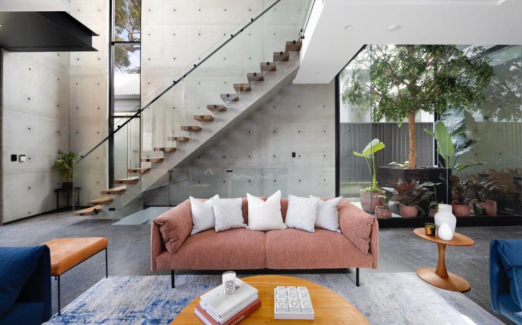 a living room with a couch and a staircase at The Arc Bondi Beach in Sydney