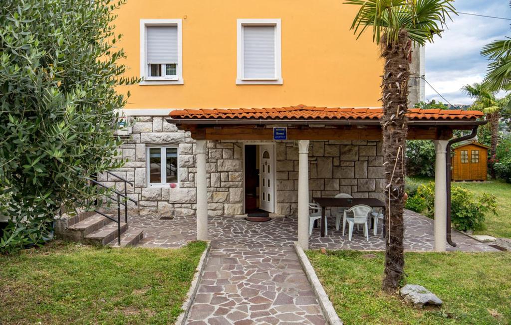 a house with a stone fireplace in front of it at Vallelosca Garden in Opatija