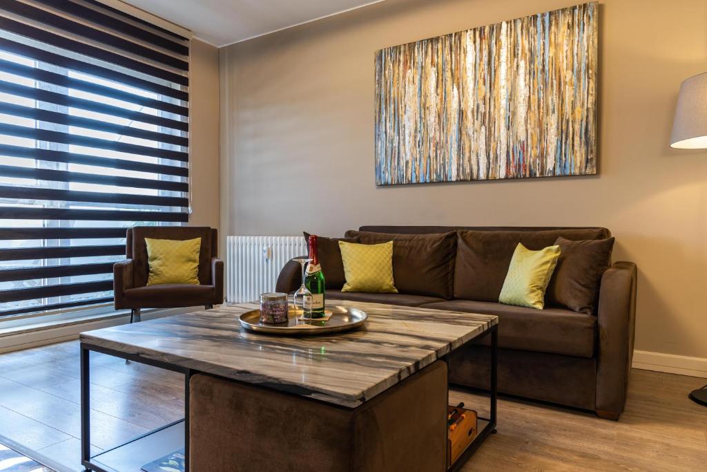 een woonkamer met een bank en een tafel bij Deluxe Apartment mit Tiefgarage in Nähe Messe-BMW-Porsche-DHL-Flughafen-Flugzeugwerk der Deutsche Aircraft in Leipzig