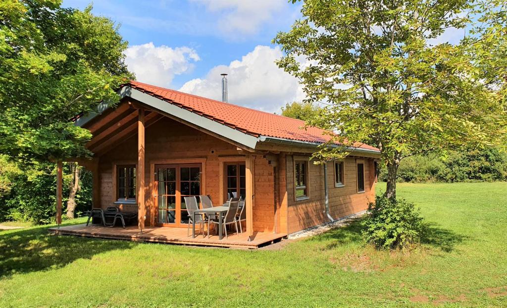 Cabaña de madera pequeña con terraza en un campo en Ökologisches Holzblock-Ferienhaus 150 im Lauterdörfle zu vermieten - Neubau, en Hayingen