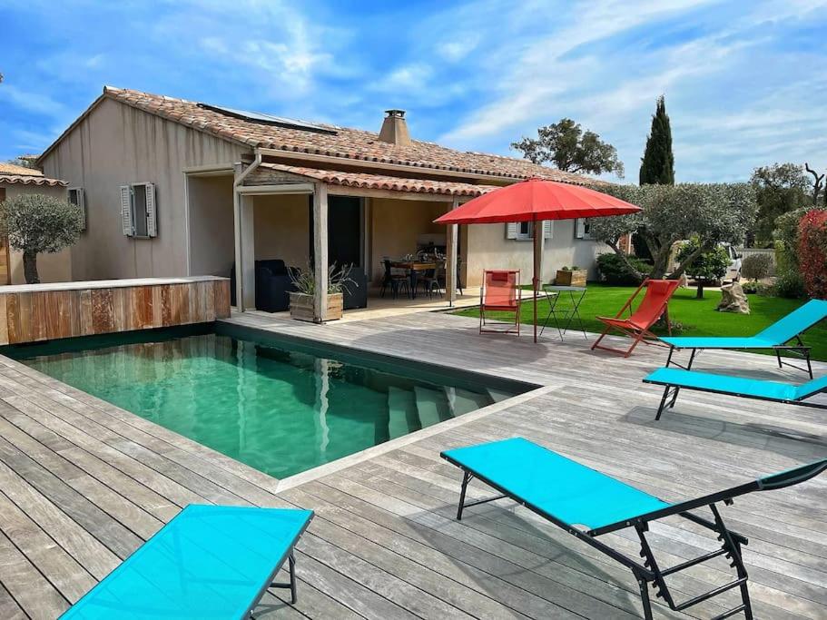 a backyard with a pool and chairs and a house at Villa avec piscine privée à Sainte Lucie in Sainte-Lucie de Porto-Vecchio
