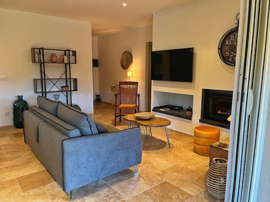 a living room with a blue couch and a fireplace at Villa avec piscine privée à Sainte Lucie in Sainte-Lucie de Porto-Vecchio