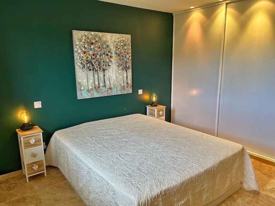 a bedroom with a bed and a painting on the wall at Villa avec piscine privée à Sainte Lucie in Sainte-Lucie de Porto-Vecchio
