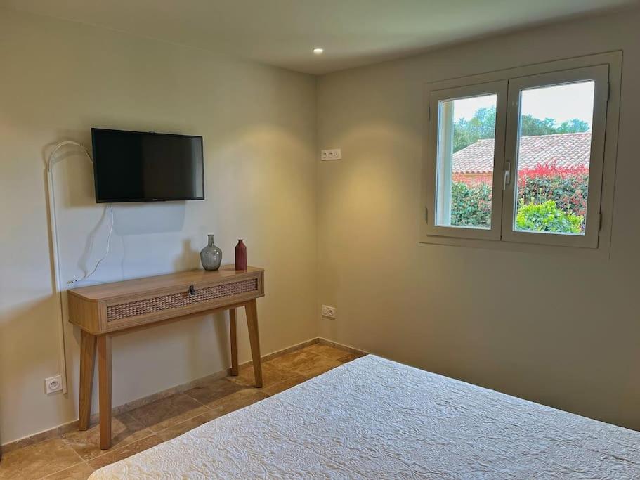 a bedroom with a bed and a television on the wall at Villa avec piscine privée à Sainte Lucie in Sainte-Lucie de Porto-Vecchio