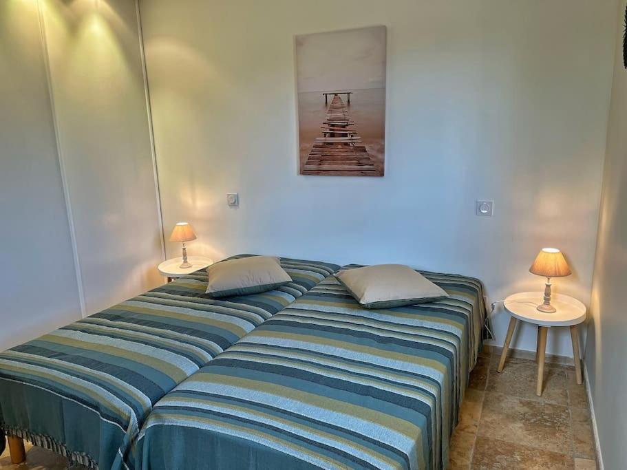 a bed in a room with two lamps on tables at Villa avec piscine privée à Sainte Lucie in Sainte-Lucie de Porto-Vecchio
