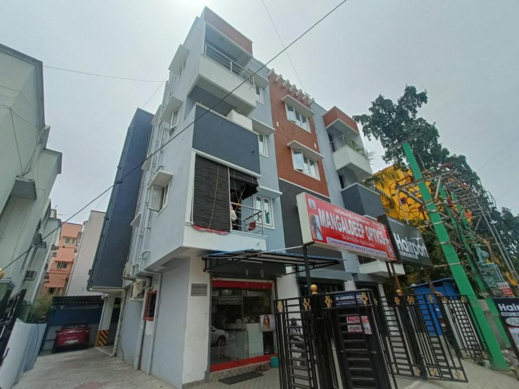 un edificio con una señal delante de él en New Metro Serviced Apartment en Chennai