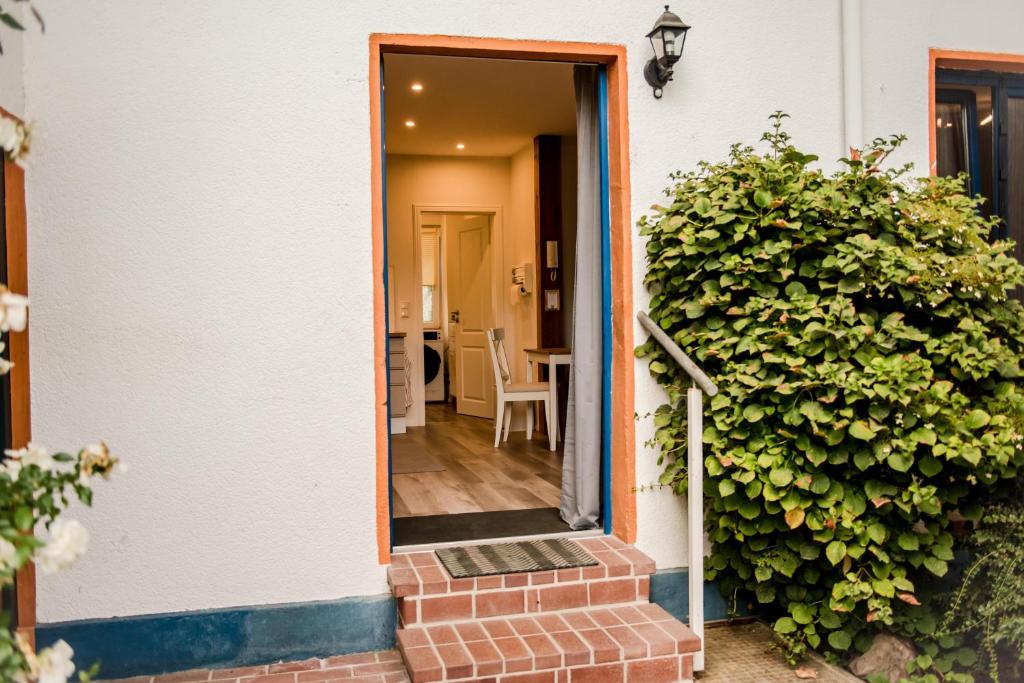 une porte menant à une maison avec une haie verte dans l'établissement Ferienwohnung Bad Vilbel, à Bad Vilbel