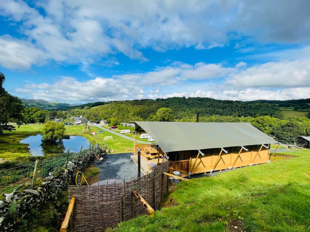 een uitzicht boven een paviljoen met een rivier op de achtergrond bij Quirky Safari Tent with Hot Tub in Heart of Snowdonia in Dolgellau