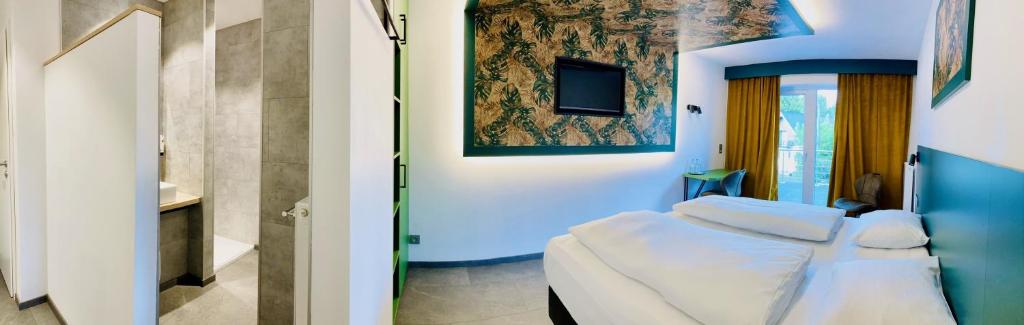Postel nebo postele na pokoji v ubytování RAVeL Hotel Cyrano